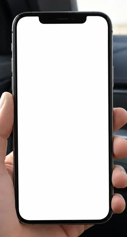 Una mano tiene uno smartphone dentro un'auto ferma, con il cruscotto scuro sullo sfondo.